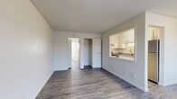 Located at 291 W Belleview Ave in Englewood, Colorado, this one-bedroom, one-bathroom unit offers a well-organized and efficiently designed single-floor layout. Throughout the space, durable wood-look plank flooring in a neutral gray tone provides a clean, cohesive aesthetic that complements the crisp white walls and textured ceilings.

The living area is open and functional, benefiting from natural light through window blinds and a direct sightline to the pass-through kitchen. The kitchen features white cabinetry, a countertop with sink, and a stainless steel refrigerator, all visible through the open pass-through window that connects seamlessly to the living space.

The bedroom offers a comfortable footprint with a window that brings in natural light, a baseboard heating unit, and access to a dedicated closet with built-in shelving. A second closet is conveniently located just off the living area, providing additional storage capacity.

The full bathroom is finished with white cabinetry, a gray countertop vanity, wood-look flooring, and a tub/shower combination with a sliding glass door, along with a small window for ventilation and natural light.

Overall, the unit presents a clean, move-in-ready environment with a neutral palette and practical layout suited for everyday living.
