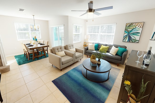 Model at Amberton Townhomes featuring a ceiling fan and windows - Amberton Luxury Townhomes