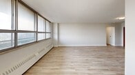 This 680 square foot apartment in Toronto offers a blend of modern design and functional living. The single-floor layout encompasses one bedroom, one bathroom, and an open-concept kitchen and living area. The space is characterized by its contemporary finishes, including light wood-toned flooring throughout and crisp white walls that enhance the sense of brightness and space.

The kitchen is a standout feature, boasting sleek white cabinetry, stainless steel appliances, and a practical galley-style layout. It opens seamlessly into the living area, creating an ideal space for entertaining or relaxing. Large windows in the main living space and bedroom flood the apartment with natural light and offer urban views, while also providing a sense of spaciousness.

The bedroom, measuring 180 square feet, offers ample space for a comfortable retreat. The bathroom features a clean, modern design with a white color scheme and a full-sized bathtub. Throughout the apartment, recessed lighting and modern fixtures add to the contemporary ambiance.

Storage solutions are integrated into the design, with built-in closets in the bedroom and additional cabinetry in the living area. The overall layout maximizes the use of space, making this compact apartment feel larger than its actual square footage suggests. Located at 10-50 Carabob Court, this unit provides a perfect balance of style and functionality for urban living in Toronto.
