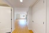 Located at 605 Concord Ave in Cambridge, MA, this efficiently designed single-floor unit offers a clean, modern aesthetic throughout. The open-plan kitchen and living area serves as the heart of the space, featuring light hardwood flooring, crisp white walls, and track lighting that enhances the bright, airy atmosphere. A large window at the far end of the living area fills the space with natural light and frames views of surrounding greenery and the neighborhood beyond.

The kitchen is equipped with stainless steel appliances, including a refrigerator and gas range, complemented by white cabinetry and ample counter space. A dedicated pantry provides additional storage. The entrance corridor leads efficiently into the main living area, with a closet and laundry facilities conveniently positioned nearby.

The bathroom is thoughtfully finished with large-format dark slate-style floor tiles, a frameless glass walk-in shower with floor-to-ceiling gray tile surround, a white vanity, and brushed nickel fixtures, lending a polished, contemporary feel. Multiple interior doors provide privacy and organization throughout the unit. The overall design prioritizes functionality and a clean, modern sensibility, making this a well-appointed space in the heart of Cambridge.