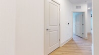 Located at 900 Laura Oaks Blvd in Kissimmee, Florida, this well-appointed 2-bedroom, 2-bathroom residence offers a clean, modern aesthetic across a single floor. Light hardwood flooring flows seamlessly throughout every room, complementing the crisp white walls and creating a bright, cohesive atmosphere.

The open-concept kitchen and living area serves as the heart of the home. The kitchen is outfitted with stainless steel appliances — including a refrigerator with ice maker, range, microwave, and dishwasher — paired with two-tone cabinetry in white and warm wood finishes. A granite-topped island provides additional prep and seating space, while stylish pendant lighting adds a contemporary touch. Natural light enters through a nearby window, enhancing the airy feel.

The primary bedroom is generously sized, featuring large windows with outdoor views, a ceiling fan, and access to a dedicated closet as well as a private en-suite bathroom. The primary bath is elegantly finished with a dual-sink granite vanity, warm wood cabinetry, framed mirrors, and a glass-enclosed walk-in shower with tile surround. The second bedroom is equally well-lit and includes its own closet access and proximity to the second bathroom. Both closets offer wire shelving for organized storage. The hallway connects all spaces cleanly, reinforcing the home's efficient and modern layout.