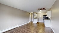 Located at 14072 E Iowa Dr in Aurora, Colorado, this single-floor unit offers a straightforward and functional layout with consistent finishes throughout. The open-concept living area is finished with durable wood-style flooring, neutral taupe-toned walls, and a textured ceiling. A ceiling fan with integrated lighting serves the space, while a baseboard heating system and a wall-mounted air conditioning unit provide year-round climate control. A sliding glass door allows access to an outdoor area and brings in natural light.

The kitchen flows directly from the living area and features white cabinetry, light granite-style countertops, a tile backsplash, and a full suite of black appliances including a refrigerator, electric range with overhead ventilation, and dishwasher. The sink is positioned along the lower cabinetry, and the kitchen benefits from overhead lighting.

The bedroom is carpeted for comfort and includes a ceiling fan, a window with blinds offering natural light, and baseboard heating. Closet access is available nearby.

The bathroom is clean and functional, featuring a full-size tub and shower combination with white tile surround, a toilet, and classic fixtures. The overall aesthetic is neutral and move-in ready.
