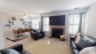 Located at 114 Bent Tree Ln in Schaumburg, Illinois, this single-floor residence offers a well-organized layout with distinct living, sleeping, and kitchen zones. The living room serves as the centerpiece of the home, anchored by a tile-surround fireplace topped with a wall-mounted television. Multiple windows flood the space with natural light, and a ceiling fan contributes to year-round comfort. The room comfortably accommodates generous seating arrangements, with light-toned carpet and a woven area rug adding warmth underfoot. A second living area or den provides additional gathering space, also accented by a framed gallery wall and proximity to the entry.

The kitchen features warm oak cabinetry extending to the upper walls, offering substantial storage alongside a full suite of white appliances, including a range and refrigerator. Light tile flooring transitions seamlessly throughout the kitchen area.

The bedrooms are finished with plush carpet and painted in soft, muted tones that create a calm and restful atmosphere. Natural light filters through windows dressed with sheer curtains and blinds. A notable feature is the walk-in closet, equipped with built-in shelving and hanging rods, providing practical and organized storage. A bathroom with oak cabinetry completes the private quarters of the home.