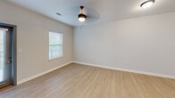 Located at 4582 Ruby Red Drive in Chattanooga, TN, this well-appointed one-bedroom, one-bathroom apartment offers a thoughtfully designed open-concept layout. Light-toned hardwood-style flooring flows throughout the main living area, complementing the neutral wall palette and creating a bright, cohesive atmosphere.

The kitchen is a standout feature, showcasing rich dark-stained cabinetry, stainless steel appliances including a range, microwave, and refrigerator, and a striking marble-look countertop that extends across a generous island with pendant lighting overhead. A classic white subway tile backsplash adds a polished finishing touch. A washer and dryer are conveniently tucked just off the kitchen area.

The open living space benefits from multiple windows dressed with horizontal blinds, allowing for controlled natural light throughout the day. The bedroom offers plush carpeting, dual windows for added brightness, a ceiling fan with light fixture, and a spacious walk-in closet with built-in shelving. Stylish two-panel gray interior doors add a modern touch throughout.

The bathroom is clean and functional, featuring a full soaking tub and shower combination with built-in corner shelving. Overall, this apartment delivers a modern, move-in-ready aesthetic with practical amenities in a comfortable Chattanooga setting.