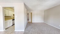 Located in Saint Petersburg, FL, this one-bedroom, one-bathroom residence offers a well-organized single-level layout designed for comfortable everyday living. The living room welcomes you at the entrance, featuring soft carpet flooring, neutral beige walls, a textured ceiling, and a window that brings in natural light with views of the surrounding area. Light wood-look flooring transitions the space toward the kitchen and dining areas. The galley-style kitchen is thoughtfully appointed with white cabinetry, neutral countertops, a stainless steel sink and dishwasher, and light wood-look flooring that keeps the space feeling bright and clean. Adjacent to the kitchen is a dedicated dining room and a pantry, offering practical storage for daily essentials. A hallway connects the main living areas to the private bedroom wing. The bedroom is generously sized, finished with plush carpet and neutral tones, and features built-in shelving alongside a walk-in closet with additional shelving for ample storage. The full bathroom includes a tiled shower-tub combination and clean white fixtures. Three closets throughout the unit provide excellent storage capacity, rounding out this efficiently designed and well-maintained residence.