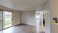 Located at 142 S Maplewood St in Greenville, Michigan, this single-floor unit offers four bedrooms and one bathroom within a compact, efficiently arranged layout. Wood-look flooring flows consistently throughout the home, complementing the neutral gray and beige wall tones that create a clean, understated aesthetic. Textured ceilings add a classic touch, while baseboard heating units are present throughout the space.

The living room is a comfortable gathering area featuring a sliding glass patio door that draws in natural light and offers views of the surrounding greenery. An entry closet with sliding doors provides convenient storage near the front entrance. The galley-style kitchen is well-equipped with warm wood cabinetry, ample counter space, stainless steel appliances including a refrigerator, range, and dishwasher, and a double-basin sink beneath overhead cabinets.

A central hallway connects the four bedrooms, each featuring wood-look flooring and neutral walls. Several bedrooms include closets with sliding doors and built-in shelving for storage. Windows allow natural light to filter in, with views of the neighborhood surroundings. The single full bathroom is fitted with a tub-shower combo, clean white fixtures, and a curtain rod, offering functional simplicity throughout.
