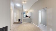 Located at 2511 Packard St in Ann Arbor, MI, this 3-bedroom, 2-bathroom unit offers a well-designed single-floor layout that maximizes functionality and comfort. The open-concept living and kitchen area is anchored by striking vaulted ceilings that lend an airy sense of spaciousness. The living room features plush carpeting, neutral warm-toned walls, a cozy corner fireplace, and a large sliding glass door that fills the space with natural light and provides access to an outdoor patio with wooded views. The kitchen is thoughtfully appointed with white shaker cabinetry, stone-look countertops, a classic subway tile backsplash, stainless steel appliances including a refrigerator, microwave, and range, and durable wood-look flooring. A ceiling fan and window add natural ventilation and light to the kitchen area. Each of the three bedrooms features soft carpeting and generous closet space, with the primary bedroom offering ample room and its own access door. The two full bathrooms are finished with white vanities featuring stone countertops, full tub-shower combos, and wood-look tile flooring. A connecting hallway ties all rooms together efficiently, completing this practical and comfortable Ann Arbor residence.