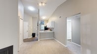 Located at 2511 Packard St in Ann Arbor, MI, this 3-bedroom, 2-bathroom unit offers a well-designed single-floor layout that maximizes functionality and comfort. The open-concept living and kitchen area is anchored by striking vaulted ceilings that lend an airy sense of spaciousness. The living room features plush carpeting, neutral warm-toned walls, a cozy corner fireplace, and a large sliding glass door that fills the space with natural light and provides access to an outdoor patio with wooded views. The kitchen is thoughtfully appointed with white shaker cabinetry, stone-look countertops, a classic subway tile backsplash, stainless steel appliances including a refrigerator, microwave, and range, and durable wood-look flooring. A ceiling fan and window add natural ventilation and light to the kitchen area. Each of the three bedrooms features soft carpeting and generous closet space, with the primary bedroom offering ample room and its own access door. The two full bathrooms are finished with white vanities featuring stone countertops, full tub-shower combos, and wood-look tile flooring. A connecting hallway ties all rooms together efficiently, completing this practical and comfortable Ann Arbor residence.