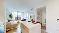 Located at 45 NE 27th St in Miami's vibrant Edgewater neighborhood, this one-bedroom, one-bathroom residence offers a thoughtfully designed open-concept layout across a single floor. The kitchen and living area flow seamlessly together, anchored by a sleek white waterfall island with seating — ideal for dining or entertaining. The kitchen is outfitted with stainless steel appliances, flat-front taupe cabinetry, a subway tile backsplash, and white quartz countertops, all complemented by light wood-style flooring that runs throughout. The living room is bright and airy, featuring floor-to-ceiling sliding glass doors that open to a private balcony with panoramic views of the Miami skyline. A ceiling fan and sheer draping curtains add to the breezy, tropical ambiance. The bedroom receives generous natural light through a large black-framed window overlooking the cityscape, creating a calm and comfortable retreat. Three closets provide ample storage throughout the unit. The bathroom features a frameless glass-enclosed walk-in shower with white tile surround and marble-style flooring. Additional conveniences include an in-unit laundry area and two hallways that enhance the overall flow of the space.