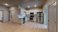 Located on Sugar Pine Drive in Houston, Texas, this single-floor unit offers a thoughtfully designed layout with modern finishes throughout. Light-toned luxury vinyl plank flooring flows consistently across all rooms, creating a clean and cohesive aesthetic.

The open living area is generously proportioned, featuring a ceiling fan with integrated lighting, vertical blinds allowing natural light, and multiple access points to adjoining spaces. The kitchen is well-equipped with white shaker-style cabinetry, granite countertops, a marble-look tile backsplash, and a full suite of stainless steel appliances including a refrigerator, range, microwave, and dishwasher. Recessed lighting illuminates the space effectively.

The bedrooms are comfortably sized with neutral-toned walls, vertical blind-fitted windows for natural light, and easy access to storage. A spacious walk-in closet features wrap-around shelving and hanging rods, providing generous organizational capacity.

The bathrooms are finished with granite-topped vanities, gray cabinetry, and tub-shower combinations adorned with elegant marble-look tile surrounds. Consistent use of gray two-panel doors with black hardware ties the interior design together throughout the unit, contributing to a clean, contemporary feel.