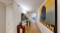 This thoughtfully designed 2-bedroom, 2-bathroom residence offers a functional and comfortable single-floor layout. The entryway hallway features light hardwood flooring that sets a warm, welcoming tone, leading residents through the unit. The kitchen is outfitted with stainless steel appliances, including a refrigerator, range, and dishwasher, complemented by white cabinetry, granite-style countertops, and a clean, galley-style configuration that maximizes efficiency. Both bedrooms are carpeted and bathed in natural light from large windows that frame lush outdoor greenery. The primary bedroom includes open closet storage and generous proportions, while the second bedroom also offers ample space with its own closet access. Each bathroom is finished with classic white tile, featuring tub-shower combinations, white cabinetry, and granite vanity countertops — one with a decorative framed mirror. A dedicated closet provides additional storage throughout the unit. The consistent use of neutral tones, hardwood-style flooring in common areas, and soft carpet in the bedrooms creates a cohesive and comfortable living environment throughout this well-organized residence.