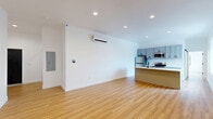Located on the 11th floor at 933 McGee St in the heart of Kansas City, MO, this one-bedroom, one-bathroom unit offers a well-designed, modern living space. Warm-toned hardwood flooring runs throughout, complementing the crisp white walls and clean-line aesthetic found in every room.

The open-concept kitchen and living area serves as the central hub of the unit. The kitchen is outfitted with grey shaker-style cabinetry with matte black hardware, white quartz countertops, a white subway tile backsplash, stainless steel appliances including a refrigerator, range, and microwave, and a kitchen island with an undermount sink — ideal for both cooking and casual dining.

The living area is bright and open, featuring recessed lighting, a wall-mounted mini-split HVAC unit, and a smart home panel. A ceiling fan adds comfort and airflow to the space.

The bedroom is a well-proportioned retreat with two large windows framing views of the Kansas City skyline, a ceiling fan, mirrored sliding closet doors, and a wall-mounted HVAC unit for personalized climate control.

The bathroom features warm hardwood-style flooring, a white vanity with under-cabinet storage, a walk-in tiled shower with a glass sliding door and matte black fixtures. An in-unit washer and dryer complete this thoughtfully appointed home.