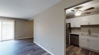 Located at 908 Ridge Square in Elk Grove Village, Illinois, this single-floor unit offers a thoughtfully updated interior with consistent hardwood-style plank flooring throughout. The open living area is bright and spacious, featuring neutral taupe walls, clean white trim, and a sliding glass door that invites natural light and provides access to the outdoors. Baseboard heating is present throughout the main living spaces, ensuring year-round comfort.

The kitchen is well-appointed with crisp white shaker-style cabinetry, light marble-look quartz countertops, a stainless steel sink, and a full suite of stainless steel appliances including a refrigerator, dishwasher, electric range, and microwave. A ceiling fan overhead adds to the kitchen's functionality.

The bedrooms are generously sized with neutral gray walls and hardwood-style flooring. One bedroom features a window with outdoor views, a wall-mounted air conditioning unit, and baseboard heating. Another bedroom includes a built-in closet with ample rod and shelf storage. Additional built-in shelving is accessible from the entryway area.

The bathroom features a clean, full-size tub-and-shower combination with white tile surround and chrome fixtures. The unit also includes a dedicated entryway with a closet, offering convenient storage upon entry.
