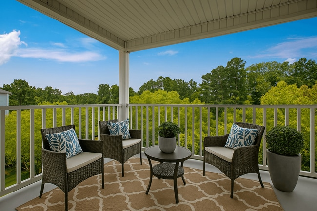 A patio with a table and chairs with a view of trees. - Canterbury Apartments