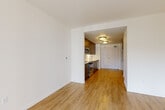 Located at 1525 SW 11th Ave in Portland's vibrant SW neighborhood, this one-bedroom, one-bathroom unit offers a thoughtfully designed layout across a single floor. Light-toned hardwood-style flooring flows throughout the main living areas, creating a cohesive and clean aesthetic.

The kitchen is outfitted with rich dark-wood cabinetry, a herringbone-patterned tile backsplash, white quartz countertops, and a full suite of stainless steel appliances including a range, microwave, dishwasher, and refrigerator. The kitchen opens directly into the living area, promoting an open, connected feel.

The living room is a standout space, anchored by a striking bay window that floods the room with natural light and offers views of the surrounding Portland cityscape. The bright, airy atmosphere is enhanced by crisp white walls and the warm flooring underfoot.

The bedroom is a quiet, well-proportioned retreat with neutral carpeting and clean white walls. The bathroom features a dark-wood vanity with an undermount sink, a large mirror, and light-toned tile flooring, maintaining the modern and consistent design language found throughout the unit.

A hallway entry with ample cabinetry provides practical storage solutions. The overall design is modern, minimalist, and move-in ready.