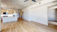 Located at 101 Main St N in Saint Petersburg, FL, this contemporary 2-bedroom, 2-bathroom residence offers a thoughtfully designed single-floor layout with high-end finishes and an urban aesthetic. Light wood-tone flooring runs seamlessly throughout, complementing the exposed concrete ceilings that lend an industrial-chic character to the space.

The open-concept kitchen and living area serves as the heart of the home. The kitchen is outfitted with light wood cabinetry, a white quartz countertop island, stainless steel appliances, a subway tile backsplash, and elegant pendant lighting with gold accents. A barn-style door adds a distinctive design touch to the living area, which also features a ceiling fan and generous open space.

The primary bedroom is bathed in natural light through dramatic floor-to-ceiling windows that frame sweeping views of the Saint Petersburg skyline and surrounding landscape. Both bedrooms offer clean, neutral walls and wood-look flooring. Three well-sized closets, including wire-shelved walk-in storage, provide ample organization throughout.

Both bathrooms are finished with warm wood vanities, white quartz countertops, framed mirrors, matte black fixtures, and glass-enclosed showers with wood-plank tile flooring — delivering a spa-like feel. Two hallways connect the spaces efficiently, completing this polished and modern residence.