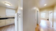 This single-story unit in Berkeley, CA offers a practical and cohesive layout across its interior rooms. Warm hardwood flooring runs throughout much of the space, lending a consistent sense of continuity from room to room. The hallway connects the main living areas efficiently, with a large closet providing ample built-in storage and a door leading into a bathroom that features warm wood-toned cabinetry, a pedestal sink, and classic tile detailing.

The kitchen is a functional highlight of the unit, outfitted with cream-colored cabinetry, dark granite countertops, a white gas range with an over-the-range microwave, and a decorative tile backsplash that adds visual interest. A connected area with light tile flooring and dual windows brings in natural light and provides additional counter and cabinet space, ideal for use as a dining nook or pantry extension.

The bedrooms are bright and simply finished, each featuring hardwood floors and windows fitted with blinds that allow for natural light while maintaining privacy. The rooms offer clean, neutral walls with subtle textured finishes in some areas. Overall, the space presents a straightforward, well-maintained interior with classic Berkeley-area character.