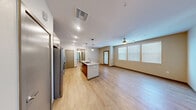Located in Las Vegas, NV, this 2-bedroom, 2-bathroom residence offers a thoughtfully designed open-concept layout that maximizes functionality and flow. Light wood-style flooring runs throughout the main living areas, complemented by neutral warm-toned walls and recessed lighting that keep the space feeling bright and welcoming.

The kitchen serves as a central focal point, featuring a large granite-topped island with an undermount sink and globe pendant lighting overhead. Rich wood-toned cabinetry lines the walls alongside a full suite of stainless steel appliances, including a French door refrigerator, gas range, microwave, and dishwasher. The kitchen opens seamlessly into the living area, which benefits from multiple windows dressed with blinds and a ceiling fan.

Both bedrooms are generously sized with plush carpeting, individual ceiling fans, and natural light provided by well-positioned windows. The spacious primary bedroom offers ample room for furnishings. Each bedroom is accompanied by a dedicated closet for storage.

The two bathrooms are clean and functional, each featuring a tub/shower combination with built-in shelving, granite-topped vanities with wood cabinetry, and light wood-style flooring. The overall design is modern, practical, and move-in ready.