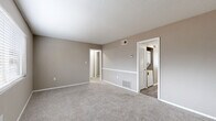 Located at 3343 Chamblee Tucker Rd in Chamblee, GA, this two-bedroom, one-bathroom unit offers a practical and comfortable single-floor layout. The living area greets you upon entry with soft carpeting, neutral taupe walls, and a front-facing window fitted with blinds that allow natural light to fill the room. The kitchen is thoughtfully designed with white cabinetry, granite-style countertops, wood-look vinyl plank flooring, a black electric range, and an open shelving unit for additional storage. A stacked washer and dryer is conveniently tucked behind louvered closet doors adjacent to the kitchen. The generously sized primary bedroom features plush carpet, a window for natural light, and direct access to the in-unit laundry area. The second bedroom also offers carpeted floors, a window with blinds, and a built-in closet with double doors. The full bathroom includes a tub-shower combination with white tile surround, a granite-topped vanity, and wood-look vinyl plank flooring that ties the space together. A connecting hallway links all rooms efficiently. The unit's consistent neutral color palette and updated finishes create a clean, move-in-ready feel throughout.