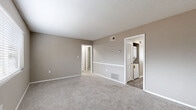 Located at 3343 Chamblee Tucker Rd in Chamblee, GA, this two-bedroom, one-bathroom unit offers a practical and comfortable single-floor layout. The living area greets you upon entry with soft carpeting, neutral taupe walls, and a front-facing window fitted with blinds that allow natural light to fill the room. The kitchen is thoughtfully designed with white cabinetry, granite-style countertops, wood-look vinyl plank flooring, a black electric range, and an open shelving unit for additional storage. A stacked washer and dryer is conveniently tucked behind louvered closet doors adjacent to the kitchen. The generously sized primary bedroom features plush carpet, a window for natural light, and direct access to the in-unit laundry area. The second bedroom also offers carpeted floors, a window with blinds, and a built-in closet with double doors. The full bathroom includes a tub-shower combination with white tile surround, a granite-topped vanity, and wood-look vinyl plank flooring that ties the space together. A connecting hallway links all rooms efficiently. The unit's consistent neutral color palette and updated finishes create a clean, move-in-ready feel throughout.