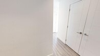 Located on the 18th floor in the heart of Calgary's SE, this 2-bedroom, 3-bathroom residence offers a sleek, contemporary design with an open-concept layout. Floor-to-ceiling windows span multiple rooms, flooding the space with natural light and framing sweeping panoramic views of the Calgary skyline and beyond. The living area is generously proportioned, featuring light wood-tone flooring that flows seamlessly throughout and direct access to a private balcony with unobstructed city views.

The kitchen is a standout, outfitted with light wood cabinetry extending to the ceiling, a gas cooktop, stainless steel appliances including a built-in wall oven and a premium refrigerator, and a large island with a quartz countertop and undermount sink — ideal for both everyday living and entertaining.

The primary bedroom enjoys its own corner window exposure with commanding city views, while the ensuite bathroom impresses with full marble-clad walls and floors, a glass-enclosed rain shower, and refined chrome fixtures. Additional bathrooms maintain the clean, modern aesthetic with white tile surrounds and a soaking tub. A well-designed hallway with built-in storage completes this polished, high-rise residence.