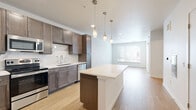 Located at 4811 S Niagara St in Denver, Colorado, this single-floor residence showcases a thoughtfully designed open-concept layout with contemporary finishes throughout. The kitchen is a standout feature, boasting rich taupe cabinetry, stainless steel GE appliances including a range, microwave, refrigerator, and dishwasher, complemented by striking marble-look tile backsplash and crisp white quartz countertops. A central island with pendant lighting serves as both a functional workspace and a natural gathering point, flowing seamlessly into the bright living area. Light wood-tone flooring extends across the main living spaces, enhancing the airy, modern atmosphere, while large windows with horizontal blinds invite generous natural light. Bedrooms offer a calm retreat — one features soft carpeting and a ceiling fan, while another presents the same warm wood-style flooring. The primary bathroom is generously proportioned with a dual-sink vanity, soaking tub, tiled shower, and direct access to a walk-in closet. A dedicated laundry area houses a full-size front-loading washer and dryer. Clean white walls, recessed lighting, and well-considered transitions between spaces give this residence a polished, move-in-ready appeal.