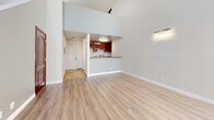 Located at 1215 N Cherokee Ave in the heart of Hollywood, Los Angeles, this two-floor loft-style residence offers a thoughtfully designed layout spread across a generous main level and a secondary upper loft. The main floor anchors the living experience with a dramatic, double-height living room that draws the eye upward with soaring ceilings and an abundance of natural light streaming through large windows dressed with vertical blinds. A tile-surround fireplace serves as a focal point, adding warmth and character to the open space. Light wood-look flooring runs throughout, lending a clean, modern aesthetic.

The kitchen opens directly to the living area via a pass-through counter, creating a seamless connection between the two spaces. Rich cherry wood cabinetry, granite countertops, a gas range, stainless steel dishwasher, and tile flooring give the kitchen a functional yet polished feel. A dedicated entryway with track lighting provides a welcoming arrival sequence.

The upper loft level, accessed from the main floor, offers a versatile secondary space complete with mirrored sliding closet doors and the same warm wood-look flooring, making it well-suited as a sleeping area or private retreat. The textured ceilings and neutral color palette throughout contribute to a cohesive, move-in-ready atmosphere.