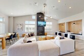 Located at 705 NW 2nd St in Waukee, Iowa, The Pitch is a thoughtfully designed amenity facility that blends contemporary style with practical functionality across a single floor. Guests are welcomed through a bright entry foyer featuring light wood-look flooring, leather accent chairs, and "The Pitch" branded signage, setting the tone for the modern aesthetic throughout.

The centerpiece of the space is an expansive lounge area with soaring vaulted ceilings, abundant natural light from large windows, and a dramatic floor-to-ceiling dark brick fireplace with a wall-mounted TV above. Plush sectional seating, gold-accented side tables, and a mid-century modern chandelier create a warm yet sophisticated gathering environment. Adjacent to the lounge is an intimate nook area featuring slatted wood-paneled built-in bench seating with pendant lighting and small round tables — ideal for casual conversations or focused work.

The kitchen is well-appointed with terracotta subway tile backsplash, dark cabinetry, a stainless steel refrigerator, a central island with bar seating, and pendant lighting overhead. The fitness center is generously equipped with treadmills, ellipticals, cable machines, free weights, stability balls, and a wall-mounted TV, all set on durable rubberized flooring with high ceilings and ample natural light. Three bathrooms complete the layout, rounding out this versatile community amenity space.