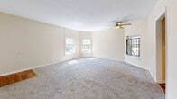 Located at 1521 S Third St in Louisville, KY, this two-bedroom, one-bathroom unit offers a practical and comfortable single-floor layout. The spacious living room greets you at the entry, featuring soft carpet, neutral cream-toned walls, a ceiling fan with light fixture, and multiple windows that allow ample natural light to fill the room. A hallway connects the main living areas to the private quarters.

The kitchen stands out with warm hardwood flooring, white shaker-style cabinetry, granite-look countertops, a double stainless steel sink, a dishwasher, and an electric range — all complemented by a window overlooking greenery outside.

The generously sized primary bedroom features plush carpet, a ceiling fan, and two windows offering pleasant outdoor views. It also includes two closets, providing excellent storage. The second bedroom is cozy and well-lit with a window and carpeted flooring, making it versatile for various uses.

The full bathroom is clean and functional, featuring tile flooring, a shower/tub combo, and a louvered linen closet for added storage.

Throughout the unit, warm beige walls, consistent carpeting, and ceiling fans create a cohesive and comfortable atmosphere suited for everyday living.