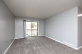 Located in West Des Moines, Iowa, this two-bedroom, one-bathroom unit offers a well-organized, single-floor layout designed for comfortable everyday living. The open living room is finished with plush carpet, neutral gray walls, and a textured ceiling, and features a sliding glass door that opens onto a private balcony, filling the space with natural light and providing outdoor views. Adjacent to the living area, the galley-style kitchen is efficiently designed with white shaker cabinetry accented by black hardware, stone-look countertops, a classic subway tile backsplash, wood-look flooring, and a full suite of stainless steel appliances including a range, microwave, and refrigerator. The full bathroom continues the modern aesthetic with wood-look flooring, a white vanity with ample counter space, black accent fixtures, and a tub-shower combination. Both bedrooms feature soft carpet, ceiling fans with light fixtures, and windows that allow natural light to flow in. The primary bedroom includes a dedicated closet with dual hanging rods and built-in shelving, offering generous storage. A separate, spacious walk-in style closet adds further storage capacity to the unit, rounding out a practical and well-appointed floor plan.