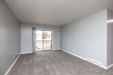 Located in West Des Moines, Iowa, this two-bedroom, one-bathroom unit offers a well-organized, single-floor layout designed for comfortable everyday living. The open living room is finished with plush carpet, neutral gray walls, and a textured ceiling, and features a sliding glass door that opens onto a private balcony, filling the space with natural light and providing outdoor views. Adjacent to the living area, the galley-style kitchen is efficiently designed with white shaker cabinetry accented by black hardware, stone-look countertops, a classic subway tile backsplash, wood-look flooring, and a full suite of stainless steel appliances including a range, microwave, and refrigerator. The full bathroom continues the modern aesthetic with wood-look flooring, a white vanity with ample counter space, black accent fixtures, and a tub-shower combination. Both bedrooms feature soft carpet, ceiling fans with light fixtures, and windows that allow natural light to flow in. The primary bedroom includes a dedicated closet with dual hanging rods and built-in shelving, offering generous storage. A separate, spacious walk-in style closet adds further storage capacity to the unit, rounding out a practical and well-appointed floor plan.