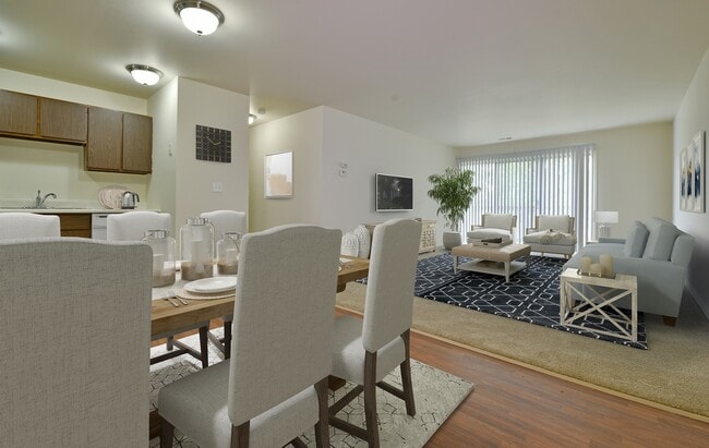 The open living room with a sliding glass door and dining room. - Grand Bend Club Apartments