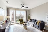 This single-floor residence showcases a contemporary design with a cohesive neutral palette, wood-look flooring, and a well-planned layout that balances open communal spaces with private retreats. The living area serves as the heart of the home, featuring floor-to-ceiling windows that frame urban skyline views and flood the room with natural light. A ceiling fan with integrated lighting adds both function and style to the space.

The kitchen is outfitted with light wood flat-front cabinetry extending to the ceiling, a decorative tile backsplash, dark countertops, and a full suite of stainless steel appliances including a gas range, built-in microwave, dishwasher, and French door refrigerator. A moveable kitchen island provides additional prep and dining space.

A hallway connects the living areas to the private quarters, where an in-unit stacked washer and dryer offer added convenience. The bedroom features plush carpeting and ample wall space. Two bathrooms serve the residence: one with a sleek glass-enclosed walk-in shower, wood-toned vanity, and backlit mirror, and a second featuring a soaking tub with marble-style tile surround. The overall ambiance is modern, clean, and well-appointed throughout.