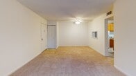 Located at 5820 Murray Dr in Hanahan, South Carolina, this single-floor unit offers a well-organized layout designed for comfortable everyday living. The spacious living area is finished with plush wall-to-wall carpeting, neutral-toned walls, and a ceiling fan with light fixture. A large window dressed with vertical blinds allows generous natural light to fill the room, creating a bright and airy atmosphere.

The bedrooms continue the carpeted flooring and neutral color palette, each featuring windows with horizontal blinds that provide both natural light and outdoor views of the surrounding greenery. The clean, open layout of each room offers flexibility for a variety of furniture arrangements.

The kitchen is equipped with warm wood-toned cabinetry providing ample upper and lower storage, a double sink, and white appliances including a full-size refrigerator and dishwasher. Light tile flooring adds a practical, easy-to-clean surface. An open shelving pantry area adjacent to the kitchen offers additional storage capacity.

The bathroom features tile flooring and a full tub-shower combination with built-in shelving niches, finished in a clean white surround. A dedicated utility room with tile flooring houses the water heater and includes washer/dryer hookups, adding functional convenience to the unit's overall design.