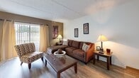 Located at 8610 Pine Tree Ct in Tampa, FL, this single-story, one-bedroom, one-bathroom home offers a practical and well-organized layout across a compact but functional floor plan. Wood-style flooring runs throughout the main living areas, providing a clean and cohesive look.

The living room serves as the central gathering space, featuring neutral walls, a large window that allows natural light to filter in, and enough room for a sectional sofa and accent seating. An accent wall adds a subtle pop of warmth to the space.

The galley-style kitchen is efficiently arranged with cream cabinetry lining both sides, a double-basin sink, ample counter space, and white appliances including a stove and refrigerator. Overhead cabinetry maximizes storage within the compact footprint.

The bedroom offers a quiet retreat with soft carpeting, a window dressed with curtain panels, and dual bifold closets providing generous storage. The room comfortably accommodates a full-sized bed and additional furniture.

The bathroom features wood-style flooring, a vanity with cream cabinetry, and a full tub-shower combination with a decorative curtain. The space is bright and functional, completing this well-appointed Tampa home.