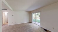 Located at 2344 Cowan Blvd, Unit 102 in Fredericksburg, VA, this single-floor unit offers three bedrooms, three bathrooms, and a practical, well-organized layout. The living room serves as the heart of the space, featuring plush carpeting and a sliding glass door that opens to a view of a lush, green outdoor area, filling the room with natural light. The kitchen is equipped with a black electric range, an overhead ventilation hood, and gray cabinetry, with easy-to-maintain hard surface flooring. Each of the three carpeted bedrooms features neutral tones and clean white walls, with the primary bedroom offering a dedicated closet with built-in shelving. Additional bedrooms include windows with blinds that bring in natural light. The three bathrooms are functional and clean, featuring white tile tub-shower surrounds, vanities with gray cabinetry, white countertops, and wood-look flooring. A dedicated laundry area adds everyday convenience. Two hallways connect the various spaces throughout the unit, ensuring an efficient flow. The overall aesthetic is clean, neutral, and move-in ready, making it a practical and comfortable home in Fredericksburg.