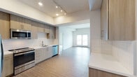 Located at 21425 Vanowen St in the Canoga Park neighborhood of Los Angeles, this single-floor residence showcases a clean, modern design with thoughtful finishes throughout. The open-concept kitchen is a standout feature, equipped with stainless steel appliances including a side-by-side refrigerator, range, built-in microwave, and dishwasher. Light wood-toned cabinetry extends to the ceiling, complemented by white quartz countertops and a crisp subway tile backsplash. Track lighting and recessed fixtures illuminate the space, which flows seamlessly into the open living area featuring wood-look flooring and a glass door that invites natural light from outside. The bedrooms offer plush carpeting, neutral walls, and windows fitted with blinds, with one room featuring a ceiling fan for added comfort. The bathrooms are finished with clean, contemporary fixtures, including a full bath with a tiled tub surround, wood-look flooring, and a vanity with a white countertop and frameless mirror. A second bathroom includes a dual-sink vanity with chrome hardware. The overall aesthetic is bright, neutral, and move-in ready, reflecting a well-designed modern living environment.