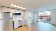 Located at 325 N 15th St in Philadelphia's vibrant Center City neighborhood, this one-bedroom, one-bathroom unit offers a well-designed layout that maximizes every square foot of its compact footprint. Light wood-tone flooring runs throughout, lending warmth and visual continuity across all rooms.

The open living area flows directly into the kitchen, which features white cabinetry, a stainless steel sink, built-in microwave, dishwasher, and refrigerator — providing efficient functionality in a clean, modern aesthetic. Bright white walls enhance the sense of openness throughout the unit.

Floor-to-ceiling windows in the living area flood the space with natural light and frame elevated views of the Philadelphia skyline and surrounding cityscape, creating a striking visual connection to the urban environment outside.

The bedroom is a well-proportioned private retreat, also benefiting from large windows with city views and light-filled interiors. A built-in wardrobe provides practical storage within the room.

The bathroom is clean and functional, finished with the same light wood flooring and featuring a walk-in shower stall and toilet in a bright white enclosure.

Overall, this unit presents a modern, minimalist aesthetic with consistent finishes throughout, making it a practical and attractive option in the heart of Philadelphia.