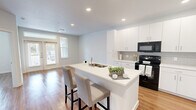Located at 8530 Phelan Blvd in Beaumont, Texas, this single-story, one-bedroom, two-bathroom residence offers a thoughtfully designed layout that maximizes functionality and comfort. The open-concept living and kitchen area serves as the heart of the home, where warm hardwood-style flooring runs throughout, complemented by crisp white walls and recessed lighting that keep the space feeling bright and inviting. A set of glass French doors allows natural light to pour into the living area, creating an airy, welcoming ambiance.

The kitchen is a standout feature, boasting white shaker-style cabinetry, a subway tile backsplash, a white quartz peninsula with bar seating for two, and black appliances including a range, microwave, and refrigerator. Ample counter and cabinet space make it highly practical for everyday use.

The bedroom is generously proportioned, featuring a ceiling fan, a large window with outdoor views, and direct access to the primary bathroom. The primary bath is clean and modern, offering a wide white vanity with quartz countertop, a large mirror, and access to a dedicated walk-in closet with built-in shelving. A second full bathroom provides added convenience for guests. Throughout, the design reflects a clean, contemporary aesthetic suited for comfortable everyday living.