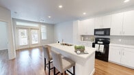 Located at 8530 Phelan Blvd in Beaumont, Texas, this single-story, one-bedroom, two-bathroom residence offers a thoughtfully designed layout that maximizes functionality and comfort. The open-concept living and kitchen area serves as the heart of the home, where warm hardwood-style flooring runs throughout, complemented by crisp white walls and recessed lighting that keep the space feeling bright and inviting. A set of glass French doors allows natural light to pour into the living area, creating an airy, welcoming ambiance.

The kitchen is a standout feature, boasting white shaker-style cabinetry, a subway tile backsplash, a white quartz peninsula with bar seating for two, and black appliances including a range, microwave, and refrigerator. Ample counter and cabinet space make it highly practical for everyday use.

The bedroom is generously proportioned, featuring a ceiling fan, a large window with outdoor views, and direct access to the primary bathroom. The primary bath is clean and modern, offering a wide white vanity with quartz countertop, a large mirror, and access to a dedicated walk-in closet with built-in shelving. A second full bathroom provides added convenience for guests. Throughout, the design reflects a clean, contemporary aesthetic suited for comfortable everyday living.