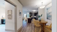 This single-floor residence is thoughtfully designed with an open-concept layout that seamlessly connects the kitchen, dining, and living areas. The kitchen is a standout feature, showcasing dark espresso cabinetry extending to the ceiling, white countertops, and a full suite of stainless steel appliances. A central island with bar seating serves as a natural gathering point, illuminated by pendant lighting overhead. Crown molding and wood-look flooring run throughout the main living areas, adding warmth and visual continuity.

The living room is bright and inviting, with large windows and a sliding glass door opening to a private balcony, allowing generous natural light to fill the space. A ceiling fan adds practical comfort to the room.

The bedrooms are carpeted and well-proportioned, each featuring multiple windows that invite natural light. The primary bedroom benefits from corner window placement, enhancing the sense of openness.

The bathrooms are finished with large-format tile flooring and dark vanity cabinetry with white countertops. One bathroom features a glass-enclosed shower alongside a window, while the second bathroom offers a spacious vanity with ample storage. Together, these spaces reflect a cohesive, contemporary design aesthetic throughout.