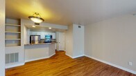 This single-story residence on Pace St in Longmont, Colorado, offers a well-organized layout with functional living spaces throughout. The open-concept living and dining area is finished with warm hardwood flooring and features a tile-surround fireplace as a central focal point. A large window and sliding glass door allow natural light to fill the space while providing outdoor views of surrounding greenery.

The kitchen is designed for practicality and style, featuring white cabinetry, granite-toned countertops, and a full suite of stainless steel appliances including a refrigerator, electric range, and over-the-range microwave. A raised breakfast bar separates the kitchen from the living area, creating an open yet defined space for casual dining. Built-in shelving near the living area adds additional storage and display options.

The bedrooms are carpeted for comfort, with one featuring access to a bathroom and a walk-in closet area, offering added convenience. The bathroom includes a tiled tub-shower combination with a classic white tile surround accented by a dark decorative tile border. Neutral wall tones and consistent finishes throughout create a cohesive and welcoming atmosphere across the entire residence.