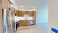 Located at 900 Chestnut St in Redwood City, CA, this thoughtfully designed one-bedroom, one-bathroom residence offers a clean, modern aesthetic throughout its single floor. Light hardwood flooring flows seamlessly across every room, unifying the space with a warm yet contemporary feel.

The kitchen is a standout feature, outfitted with flat-front wood cabinetry in a warm walnut tone, stainless steel appliances including a refrigerator, range, microwave, and dishwasher, and crisp white countertops. Recessed lighting illuminates the workspace efficiently, making it both functional and visually appealing.

The living and bedroom areas are defined by their clean white walls and minimalist design. The bedroom benefits from a large window that frames scenic views of the surrounding neighborhood and distant mountains, filling the room with natural light. A wall-mounted mini-split system provides climate control. A sliding-door closet adds practical storage.

The bathroom continues the cohesive design language with wood-toned cabinetry beneath a white vanity, a large mirror, and light hardwood flooring. The layout is compact but well-organized.

Overall, this residence offers a modern, move-in-ready environment with quality finishes and a bright, open atmosphere in the heart of Redwood City.