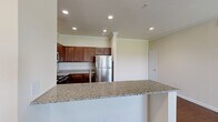 Located at 1101 Longhorn Rd in Fort Worth, TX, this well-appointed three-bedroom, two-bathroom residence offers a thoughtfully designed single-floor layout with a comfortable sense of space throughout. The open-concept kitchen and living area serves as the heart of the home, showcasing rich dark wood cabinetry, granite countertops, and a full suite of stainless steel appliances including a range, microwave, dishwasher, and refrigerator. A peninsula with a granite overhang provides a natural divide between the kitchen and living space, ideal for casual dining or entertaining. Recessed lighting and crown molding add a refined touch to the main living areas. Hardwood-style flooring flows through the kitchen and living spaces, while plush carpet adds warmth to the bedrooms. The primary bedroom features a tray ceiling detail and access to an outdoor area through a door flanked by windows. Each bedroom includes a closet with built-in rod storage. The bathrooms are finished with tile flooring, rich wood vanities with granite counters, and a tiled tub-shower combination. The overall ambiance is clean, neutral, and move-in ready, offering a comfortable and functional living environment.