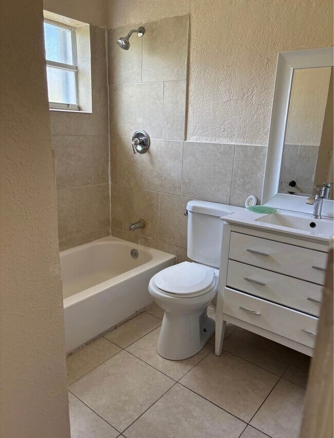 Se accede al baño desde la cocina o el dormitorio principal. - 209 NW 28th Ave
