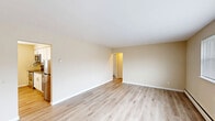 This 2-bedroom, 1-bathroom residence in Parsippany, NJ offers a well-organized single-floor layout designed for comfortable everyday living. Light-toned hardwood flooring runs throughout the space, creating a cohesive and clean aesthetic that ties each room together.

The living area is bright and open, featuring large windows that allow natural light to fill the room, a wall-mounted air conditioning unit, and baseboard heating. The updated kitchen is well-equipped with white shaker-style cabinetry, granite-look countertops, a subway tile backsplash, and a full suite of stainless steel appliances including a refrigerator, dishwasher, electric range, and over-the-range microwave. A window above the counter adds additional natural light to the space.

The spacious primary bedroom offers generous room for furnishings and includes two closets side by side, providing ample storage. A window allows for natural light and ventilation. The second bedroom is also well-sized and features its own baseboard heating. Both rooms maintain the same warm, neutral wall tones seen throughout the unit.

The bathroom is finished with classic white subway tile surrounding a full soaking tub and shower combination, accented by a decorative mosaic tile border. A window with blinds provides both light and privacy. A connecting hallway links the main living areas to the bedrooms and bathroom, contributing to an efficient and practical floor plan.