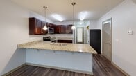 Located at 207 Kelly Rd in Clemson, SC, this three-story home offers four bedrooms, five bathrooms, and a well-organized layout spread evenly across all three levels. The ground floor welcomes you through a classic paneled entry door into an open living area with rich hardwood-style flooring. The kitchen is a standout feature, boasting deep-toned mahogany cabinetry, granite countertops, stainless steel appliances including an electric range and built-in microwave, and a large peninsula with pendant lighting and bar seating — ideal for both cooking and entertaining. Upper floors are home to the four bedrooms, each carpeted and filled with natural light through large windows that frame lush, green outdoor views. The primary bedroom includes its own closet, while four additional closets throughout the home provide ample storage. Five bathrooms feature tile flooring, full tub-shower combinations, and rich wood vanities with light countertops. A dedicated in-unit laundry room equipped with a full-size washer and dryer adds everyday convenience. Hallways and staircases connect each level efficiently, completing a functional and comfortable multi-story home.