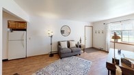 Located at 13303 Terri Lyn Ln in Holland, Michigan, this single-floor unit offers a well-organized and functional layout designed for comfortable everyday living. The living area features warm hardwood-style flooring, neutral walls, and ample natural light, creating a bright and welcoming atmosphere. A round accent mirror, decorative floor lamp, and patterned area rug contribute to the space's clean, modern-casual aesthetic. The entryway includes a convenient wall-mounted coat rack for practical everyday use.

The kitchen is equipped with warm wood cabinetry, a double-basin sink, electric range, and a dishwasher. A sliding glass door opens to an outdoor view, allowing natural light to flow into the dining area, which features a solid wood dining table and chairs alongside a charming sideboard with decorative accents.

The bathroom is neatly appointed with a single-sink vanity, a tub-shower combination, and floating wood shelves for added storage and style. Hardwood-style flooring extends into this space, maintaining a cohesive look throughout.

Two additional rooms offer versatile functionality — one carpeted room with a window and ample storage is well-suited as a bedroom or office, while another room with hardwood-style floors accommodates a dedicated home office setup. Together, these spaces provide adaptable options to suit a variety of needs.
