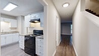 This two-story, 2-bedroom, 3-bathroom home in Stone Mountain, Georgia offers a well-organized layout across two floors. The main level features two living areas connected by an open archway, with hardwood-style flooring and large windows that invite abundant natural light. The kitchen is a standout space, outfitted with white shaker cabinetry, subway tile backsplash, granite-look countertops, a black appliance suite including a range and dishwasher, and a skylight that brightens the room. A dedicated dining room and hallway round out the main floor's functional layout. Upstairs, the primary bedroom is a spacious retreat with plush carpeting, dual windows, and two closets offering generous storage. The second bedroom also features carpet flooring and multiple windows with outdoor views. Three bathrooms serve the home, each finished with white cabinetry and light countertops; one bathroom includes a large window for natural light. Throughout the home, neutral gray tones, textured ceilings, and clean white trim create a cohesive and well-maintained aesthetic. The staircase connects both levels seamlessly, making this a practical and comfortable two-story residence.