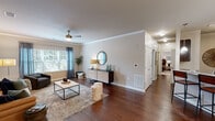 This well-designed 2-bedroom, 2-bathroom residence in Knoxville, Tennessee offers a thoughtfully laid-out single-floor plan with a cohesive, contemporary aesthetic throughout. Rich hardwood flooring extends across the main living areas, complemented by crown molding and neutral wall tones that create a bright, welcoming atmosphere.

The living room is a generous, open space anchored by a ceiling fan and large windows dressed with draping curtains, allowing ample natural light to fill the room. Adjacent to the living area, the dedicated dining room features an elegant chandelier and continues the warm hardwood flooring, providing an ideal setting for entertaining. The kitchen is equipped with dark cabinetry, granite-look countertops, and stainless steel appliances including a refrigerator, range, and microwave.

Both bedrooms are carpeted for comfort and include ceiling fans and windows that invite natural light. The primary bedroom is a well-proportioned retreat with a walk-in closet outfitted with wire shelving for ample storage. A second closet provides additional organizational space. The two bathrooms feature dark vanities with light countertops, tile flooring, and large mirrors, offering a clean and functional design.

Overall, this residence combines practical functionality with tasteful finishes, making it a comfortable and attractive home in Knoxville.